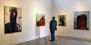 Tom Maderos examining the work of Barbara Downs at exhibition